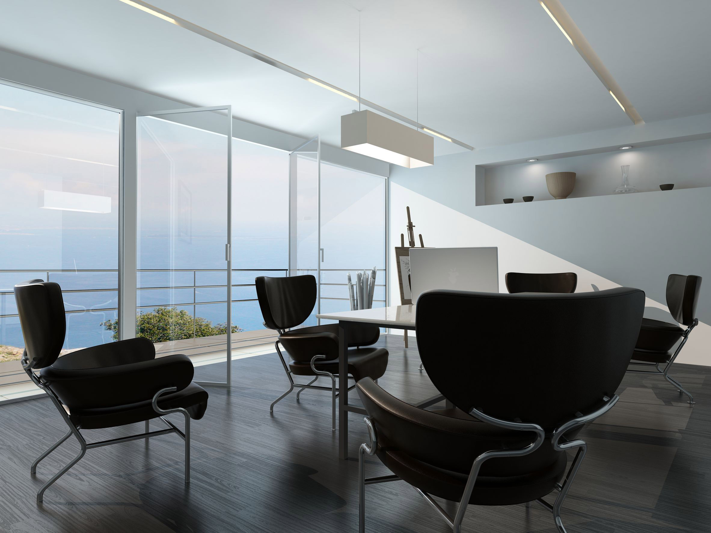 contemporary office conference room interior with scattered armchairs around a central table in front of a glass wall overlooking the ocean and an easel on a stand in the corner